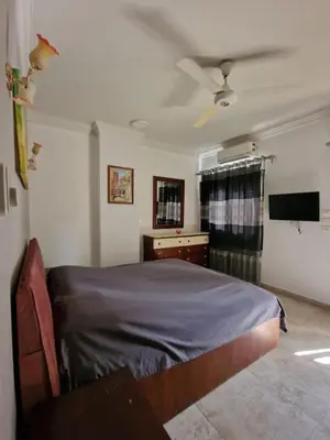 a bedroom with a bed and a flat screen tv at Kawthar Apartment in Hurghada