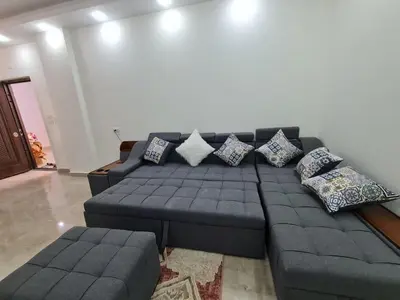 a living room with a blue couch and pillows at Golden Home Hurghada in Hurghada