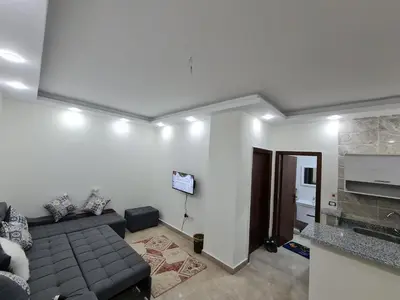 a living room with a couch and a television at Golden Home Hurghada in Hurghada