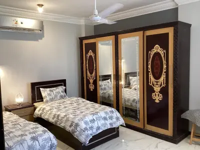 a bedroom with two beds and a mirrored cabinet at Glenholme Country House in ‘Ezbet Abu Ḥabashi