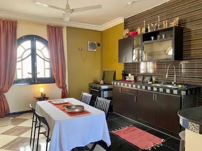 a kitchen with a table and a kitchen with a table and a sink at Glenholme Country House in ‘Ezbet Abu Ḥabashi