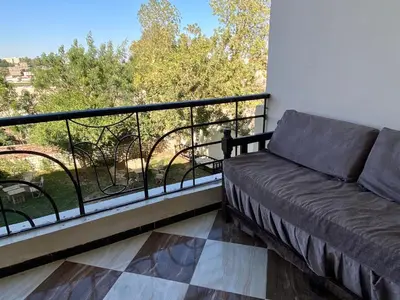a couch sitting on a balcony with a view at Glenholme Country House in ‘Ezbet Abu Ḥabashi