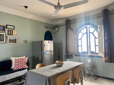 a living room with a table and a refrigerator at Glenholme Country House in ‘Ezbet Abu Ḥabashi