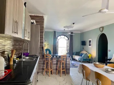 a kitchen and living room with a table and chairs at Glenholme Country House in ‘Ezbet Abu Ḥabashi