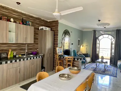 a kitchen and living room with a table and chairs at Glenholme Country House in ‘Ezbet Abu Ḥabashi