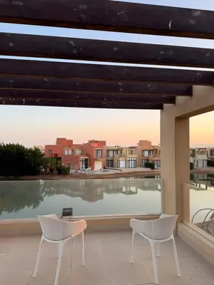 two chairs on a balcony with a view of a pool at Tawila villa 14 in Hurghada