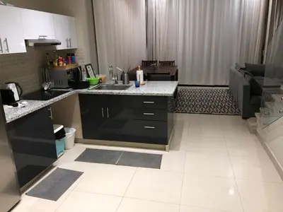 a kitchen with black cabinets and a white tile floor at Tawila villa 14 in Hurghada