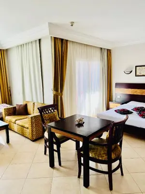 a hotel room with a bed and a table and chairs at Stylish & Cozy 50 m2 Studio Chalet in the Sunset Pearl Apartments in Hurghada