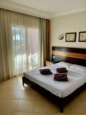 a bedroom with a bed with two pillows on it at Stylish & Cozy 50 m2 Studio Chalet in the Sunset Pearl Apartments in Hurghada