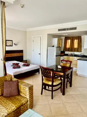 a living room with a bed and a table and chairs at Stylish & Cozy 50 m2 Studio Chalet in the Sunset Pearl Apartments in Hurghada