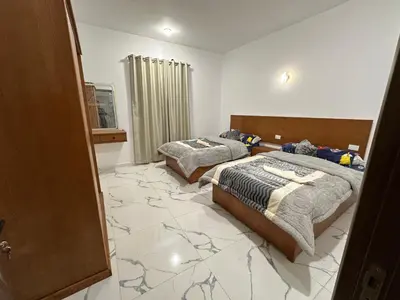 two beds in a room with a marble floor at West Mountain Home-Luxor in Al Aqālitah