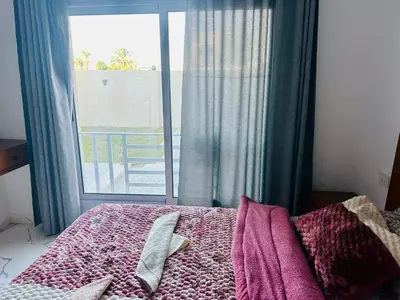 a bedroom with a bed and a large window at West Mountain Home-Luxor in Al Aqālitah