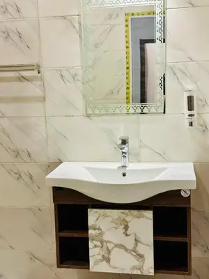 a bathroom with a sink and a mirror at West Mountain Home-Luxor in Al Aqālitah