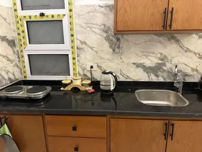 a kitchen counter with a sink and a mirror at West Mountain Home-Luxor in Al Aqālitah