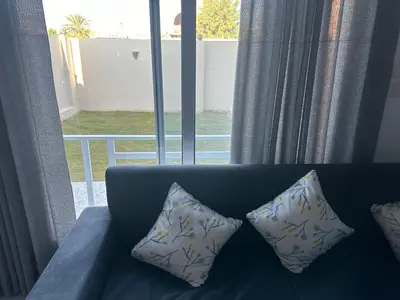 a blue couch with two pillows in front of a window at West Mountain Home-Luxor in Al Aqālitah