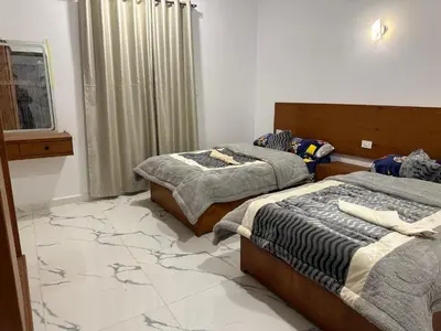 a bedroom with two beds and a window at West Mountain Home-Luxor in Al Aqālitah