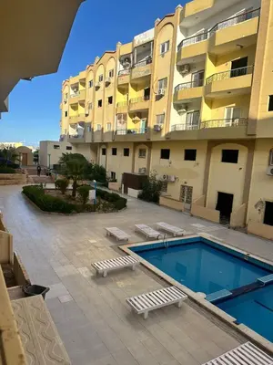 a large apartment building with a swimming pool next to a building at Luxury Studio in Hurghada