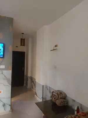 a living room with a couch and a tv on a wall at Luxury Studio in Hurghada