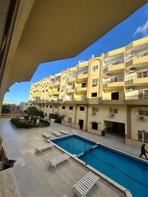 a large building with a swimming pool in front of a building at Luxury Studio in Hurghada