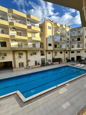 a swimming pool in front of an apartment building at Luxury Studio in Hurghada