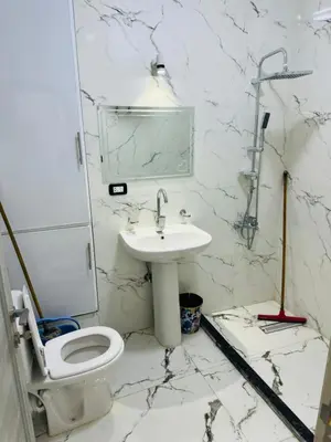 a white bathroom with a sink and a toilet at شقة بالانتر الغردقة in Hurghada