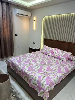 a bedroom with a bed with a purple comforter at شقة بالانتر الغردقة in Hurghada
