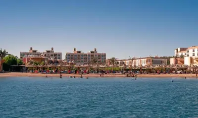 a beach with many umbrellas and people on the beach at AL Andalusia Hurghada in Hurghada