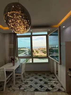 a dining room with a table and a large window at AL Andalusia Hurghada in Hurghada