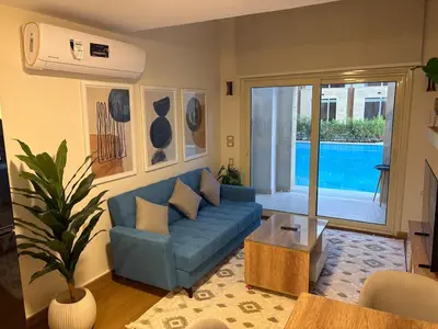 a living room with a blue couch and a pool at Duplex in Edelma Oldtown Sahl Hasheesh in Hurghada