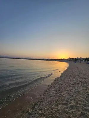 a beach with the sun setting over the water at Duplex in Edelma Oldtown Sahl Hasheesh in Hurghada