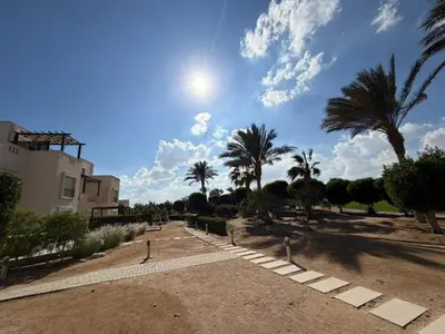 a park with palm trees and a building at Cyan Elegant 3BR Golf View Escape in Hurghada