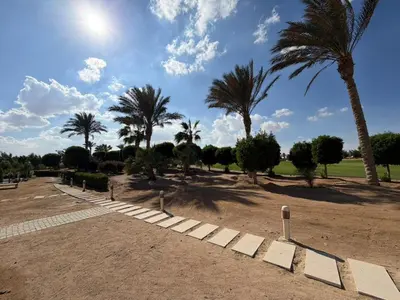 a park with palm trees and a pathway at Cyan Elegant 3BR Golf View Escape in Hurghada