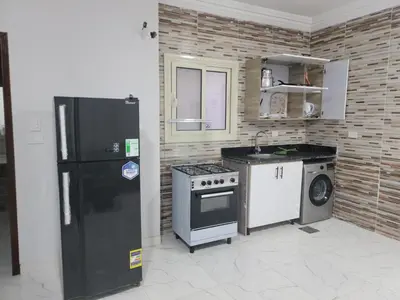a kitchen with a black refrigerator and a stove at st george in Hurghada