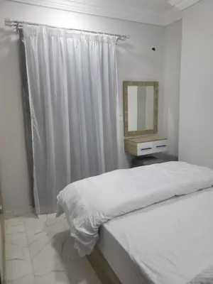 a white bedroom with a bed and a mirror at st george in Hurghada