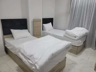 two beds in a room with white sheets at st george in Hurghada