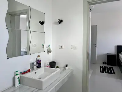 a white bathroom with a sink and a mirror at Swan Lake 3BR with Roof & Terrace in Hurghada