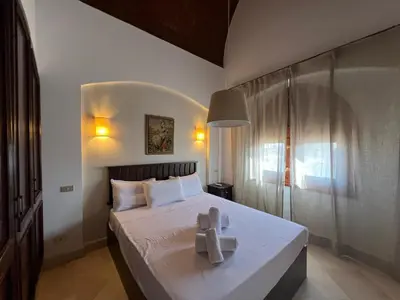 a bedroom with a bed with two crosses on it at Lagoon-Front 3BR Townhouse in Upper Nubia in Hurghada