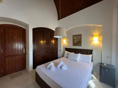 a bedroom with a white bed with two pillows at Lagoon-Front 3BR Townhouse in Upper Nubia in Hurghada