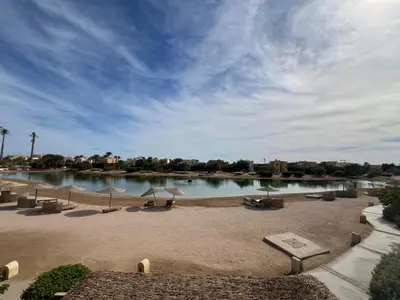 a beach with umbrellas and a body of water at Lagoon-Front 3BR Townhouse in Upper Nubia in Hurghada