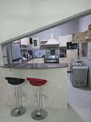 a kitchen with a counter and two bar stools at noreno houseاسوان شياخة تانية طريق السادات in Aswan