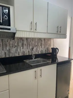 a kitchen with white cabinets and a sink at Paradise at Tiba Al Ahyaa, Hurghada in Hurghada