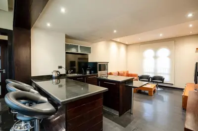 a kitchen and living room with a counter and chairs at Private Ali Pasha 2BR Pool Access + Dining Perks in Hurghada