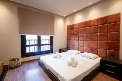a bedroom with a large bed and a window at Private Ali Pasha 2BR Pool Access + Dining Perks in Hurghada