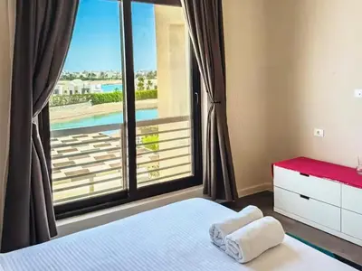 a bedroom with a window with a view of a pool at View and Location in Abu Tig Marina in Hurghada