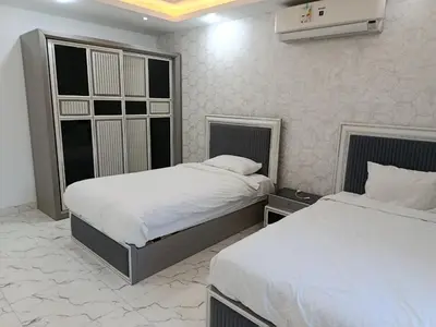 two beds in a hotel room with white sheets at Fanadir Bay in Hurghada