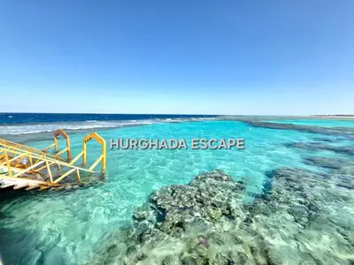 a boat in the ocean next to a reef at Gravity Sahl Hasheesh Not Egyptians in Hurghada
