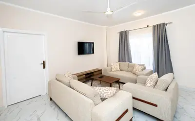 a living room with two couches and a tv at Villa Ramses in Luxor