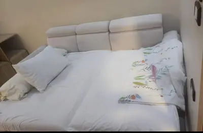 a white bed with a white headboard and two pillows at Mirage bay aquapark 772B in Hurghada