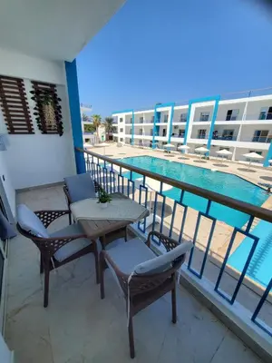a balcony with a table and chairs and a swimming pool at Mirage bay aquapark 772B in Hurghada