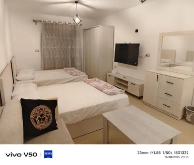 a room with three beds and a tv in it at Sahl hashish in Hurghada